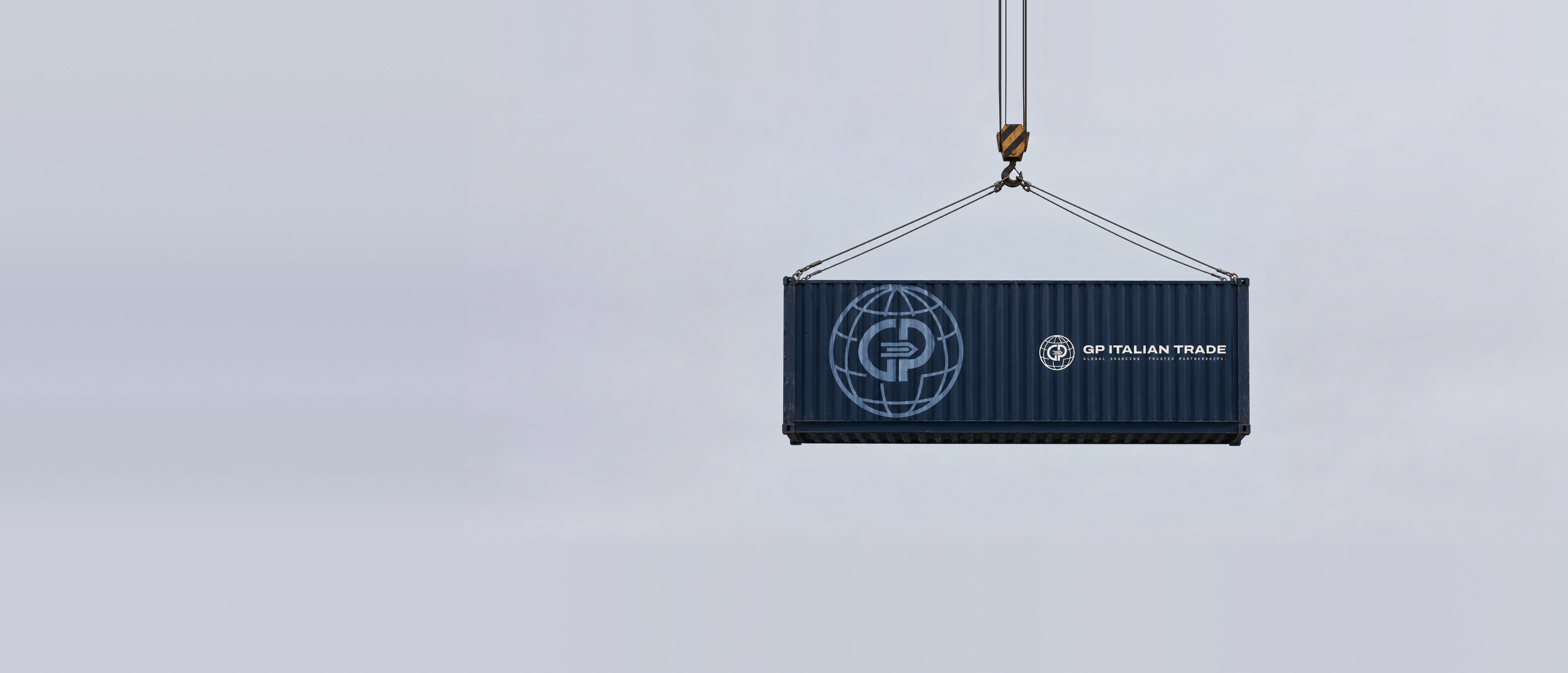 Container blu con il marchio GP Italian Trade sollevato da una gru in porto